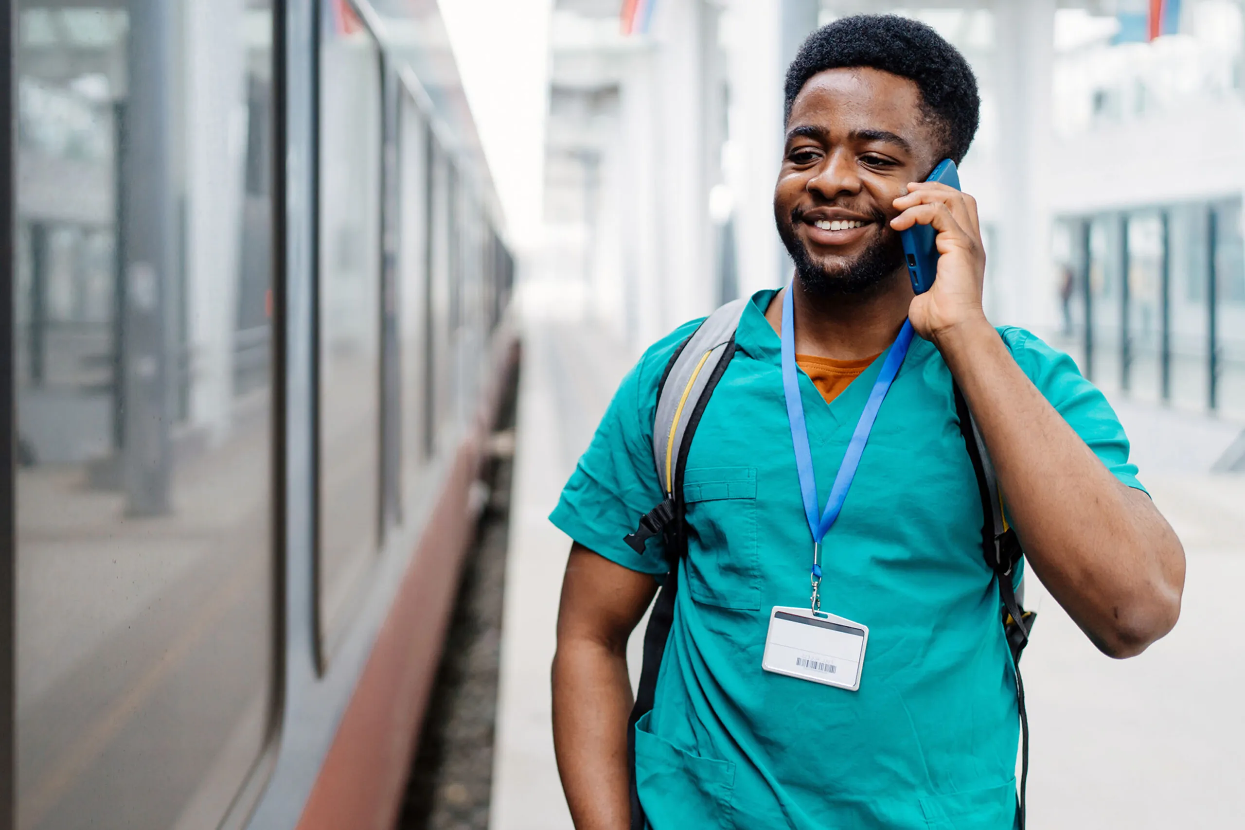 Healthcare professional on phone waiting for the train